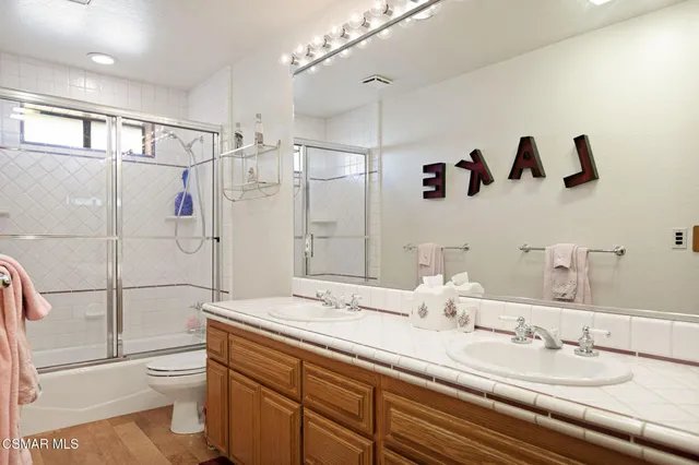 a bathroom with a double vanity sink toilet and shower