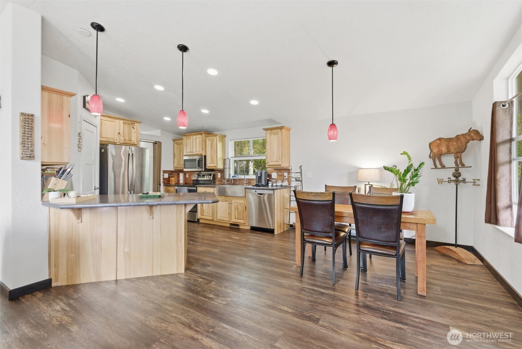 470 Sunshine Drive Sequim, WA 98382 - Photo 12 of 30 a kitchen with stainless steel appliances kitchen island granite countertop a table chairs and a wooden floor