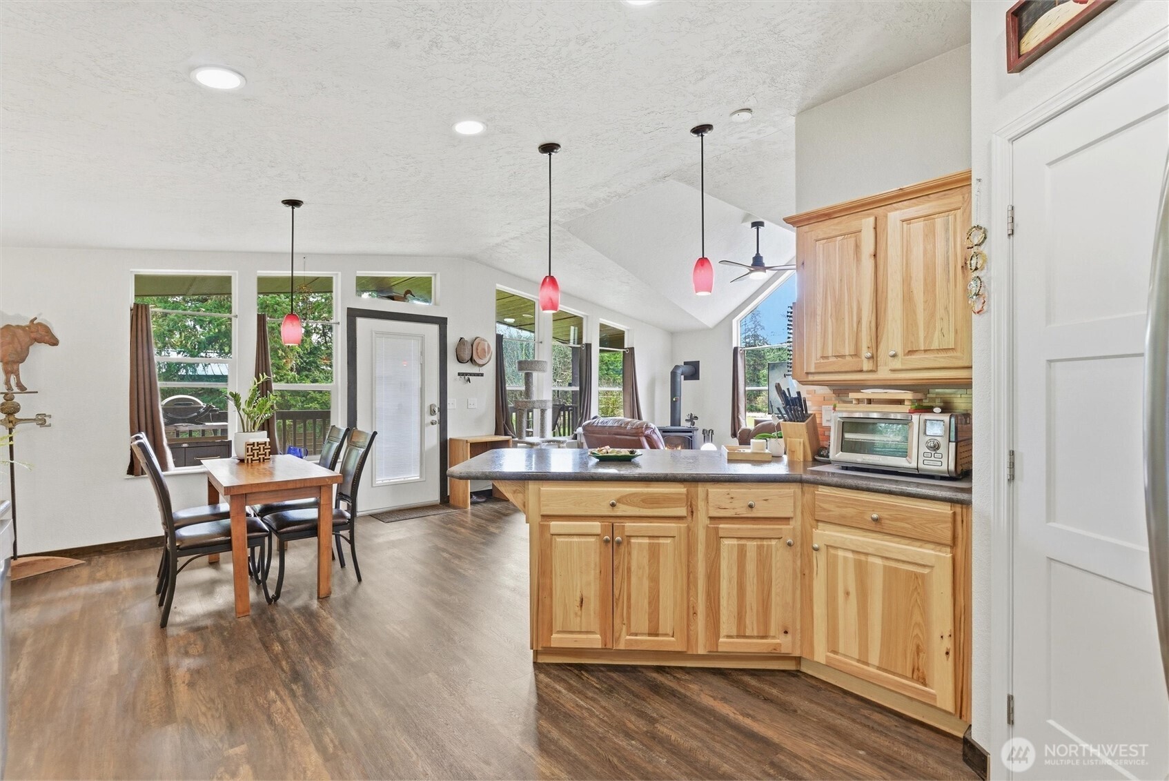 470 Sunshine Drive Sequim, WA 98382 - Photo 14 of 30 a open kitchen with granite countertop a stove a sink a dining table and chairs with wooden floor