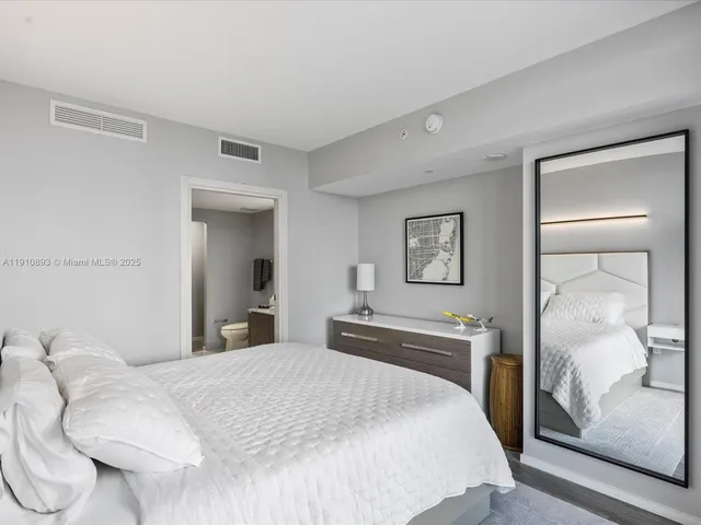 a bedroom with a bed and a mirror