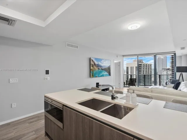 a kitchen with a sink and a stove with wooden floor