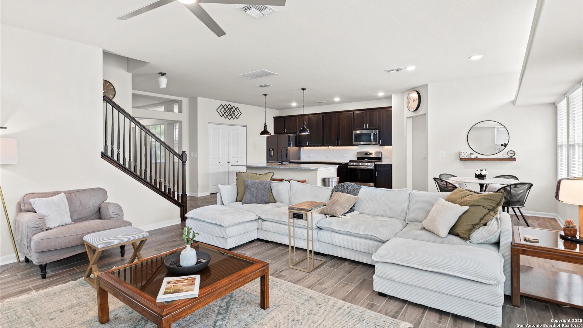 a living room with furniture a flat screen tv and kitchen view