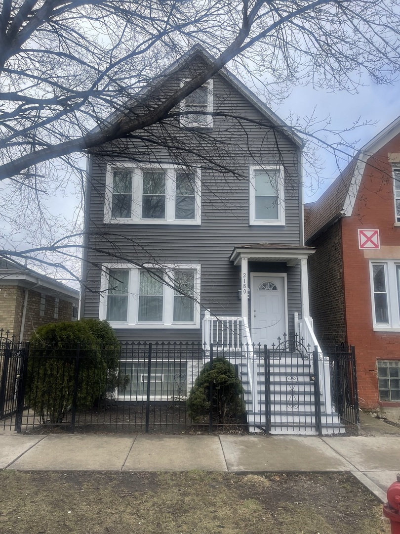 2180 North Mango Avenue Chicago, IL 60639 - Photo 1 of 18 a front view of a house with a garden