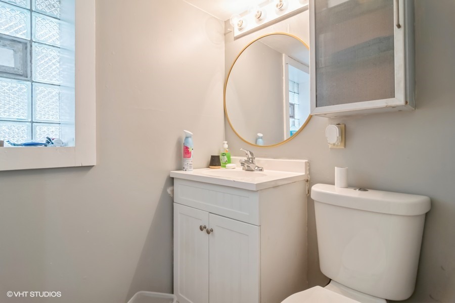 2180 North Mango Avenue Chicago, IL 60639 - Photo 12 of 18 a bathroom with a sink mirror and toilet