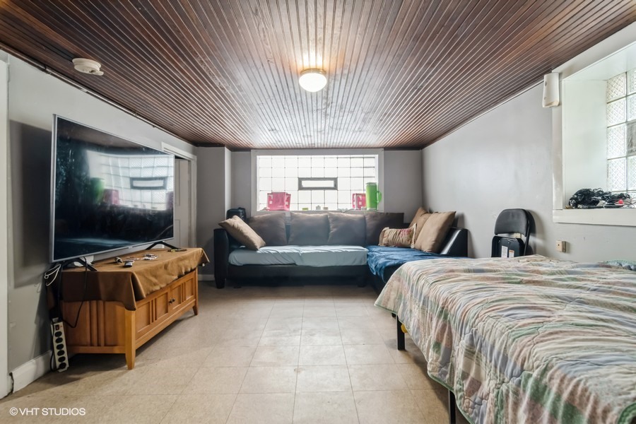 2180 North Mango Avenue Chicago, IL 60639 - Photo 13 of 18 a bedroom with bed and flat screen tv