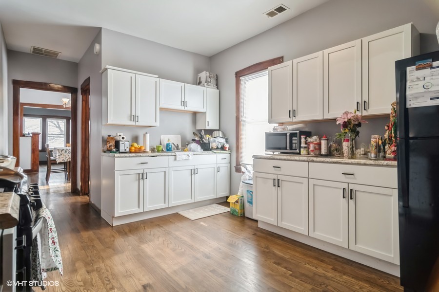2180 North Mango Avenue Chicago, IL 60639 - Photo 2 of 18 a kitchen with white cabinets and white appliances