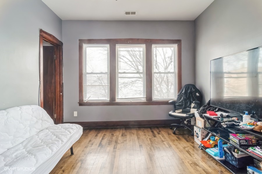 2180 North Mango Avenue Chicago, IL 60639 - Photo 5 of 18 a bedroom with furniture and a window