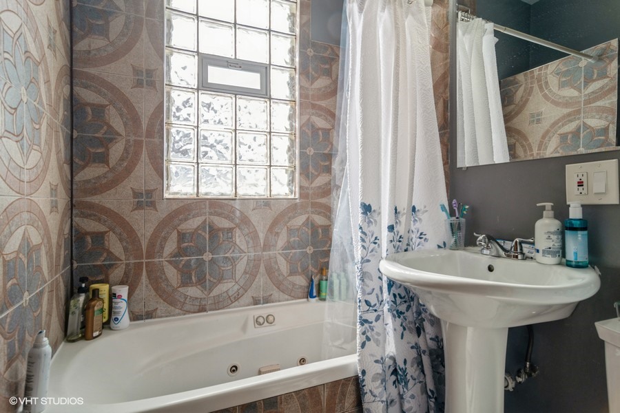 2180 North Mango Avenue Chicago, IL 60639 - Photo 6 of 18 a bathroom with a sink and a bathtub