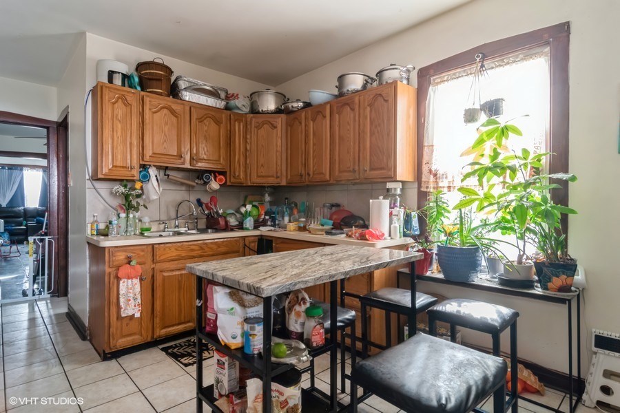 2180 North Mango Avenue Chicago, IL 60639 - Photo 8 of 18 a kitchen with a table chairs and a refrigerator
