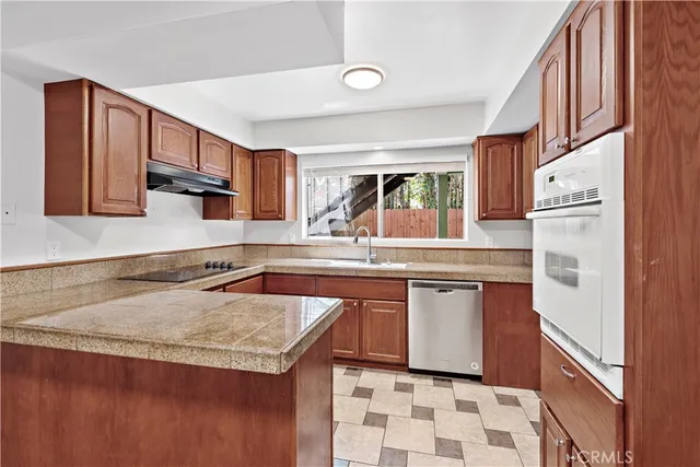 a kitchen with stainless steel appliances granite countertop a sink and a stove