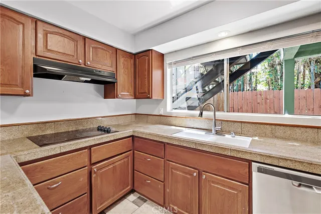a kitchen with stainless steel appliances granite countertop a sink a stove and cabinets