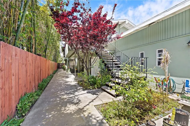 a pathway of a house with wooden fence