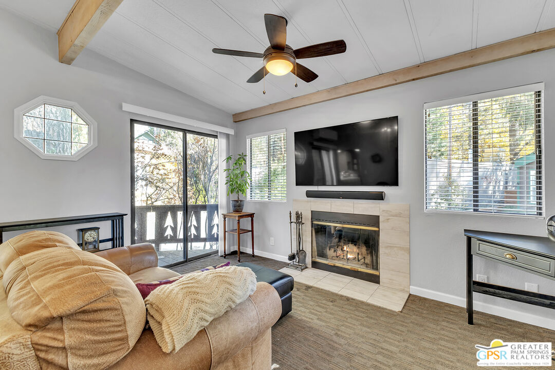 25955 Highway 243, Unit 18 Idyllwild, CA 92549 - Photo 11 of 43 a bedroom with a bed a fireplace and a flat screen tv
