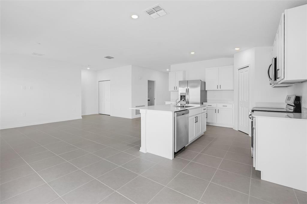 2110 Lasso Loop Eagle Lake, FL 33839 - Photo 5 of 33 a kitchen with a sink a stove top oven and white cabinets