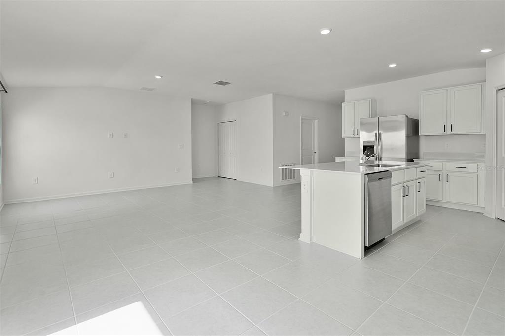 2110 Lasso Loop Eagle Lake, FL 33839 - Photo 6 of 33 a kitchen with stainless steel appliances a white stove top oven cabinets and a refrigerator