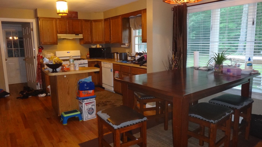 269 Dunstable Road Tyngsborough, MA 01879 - Photo 3 of 11 a kitchen with sink refrigerator dining table and chairs