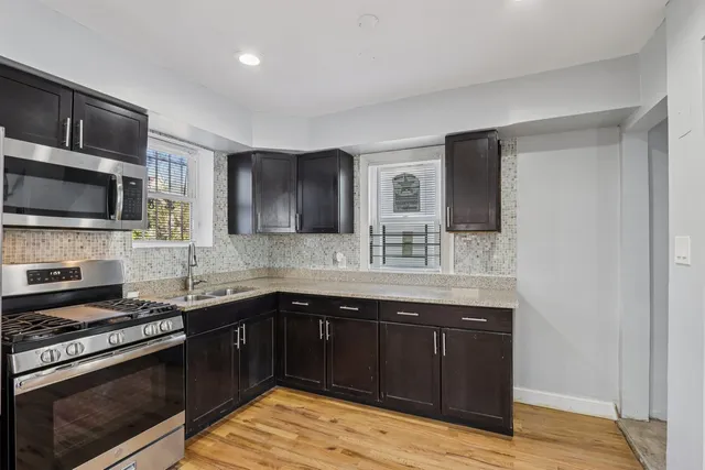 a kitchen with stainless steel appliances granite countertop a sink and stove top oven