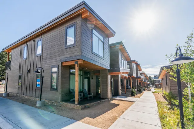 a view of a brick house with many windows next to a yard