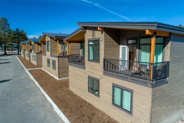 a front view of a house with swimming pool and chairs