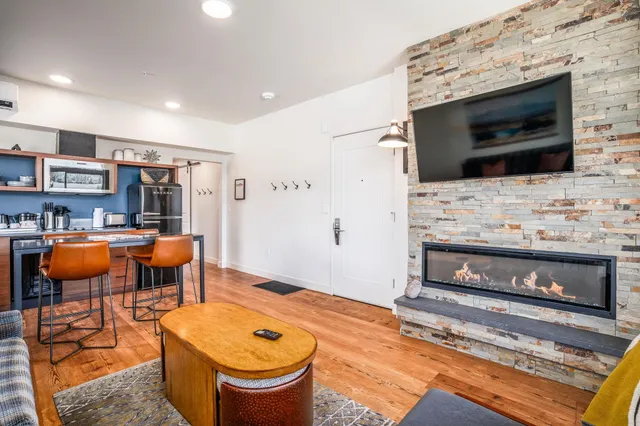 a living room with stainless steel appliances furniture and a fireplace