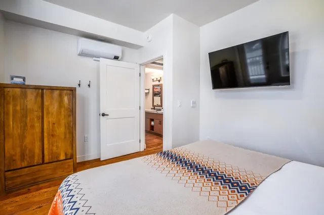 a bedroom with a bed and a flat screen tv