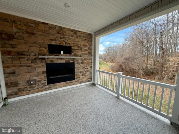 a view of an empty room with a fireplace and a floor to ceiling window