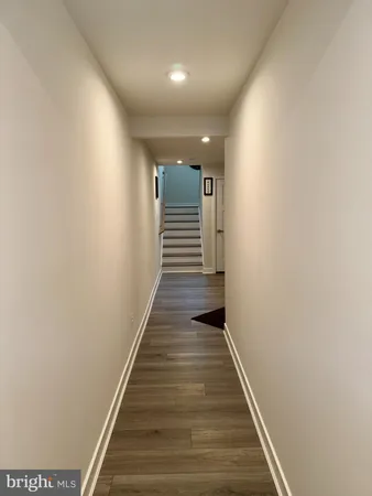 a view of a hallway with wooden floor and entryway