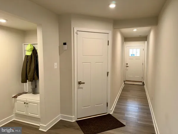 a view of a hallway with wooden floor and closet