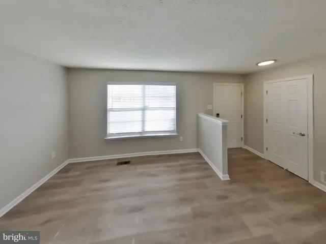 an empty room with windows and closet
