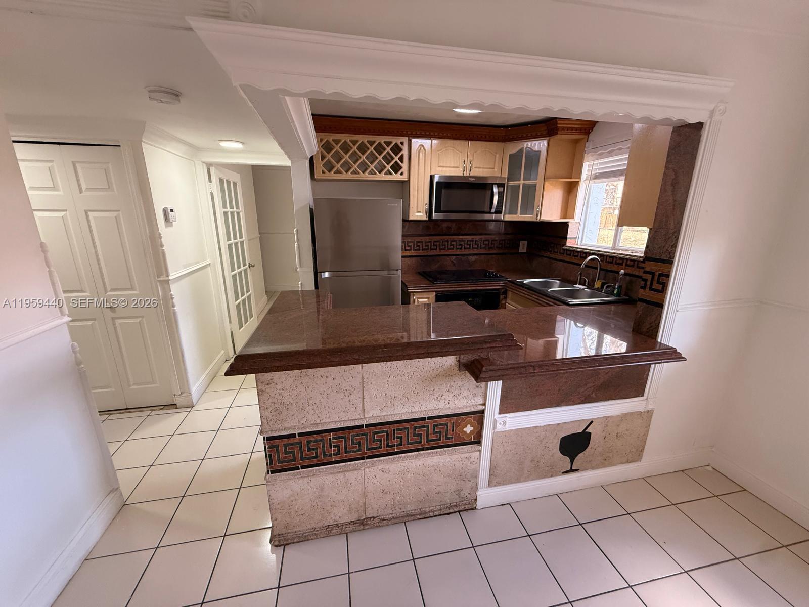 6205 Southwest 131st Court, Unit 104 Miami, FL 33183 - Photo 11 of 21 a kitchen with stainless steel appliances granite countertop a refrigerator and a stove