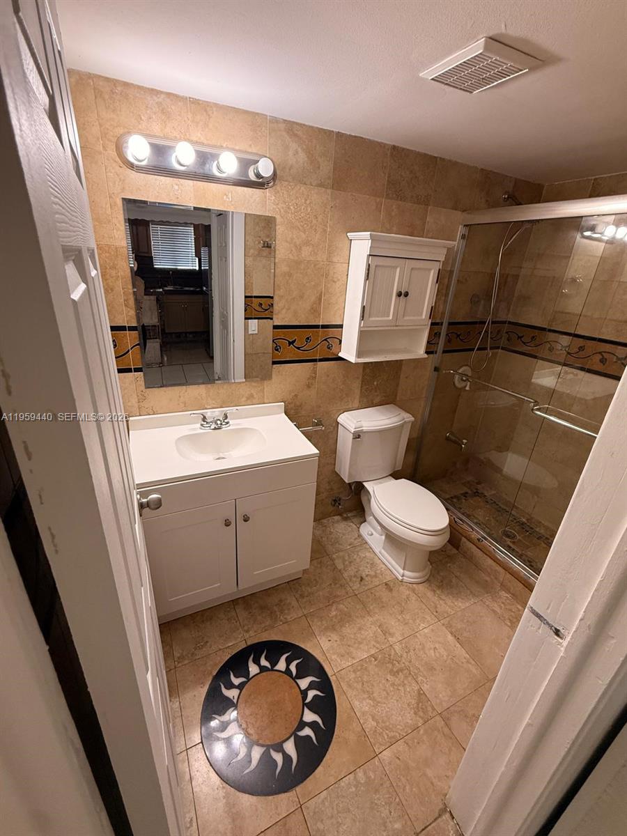 6205 Southwest 131st Court, Unit 104 Miami, FL 33183 - Photo 18 of 21 a bathroom with a sink a toilet and mirror