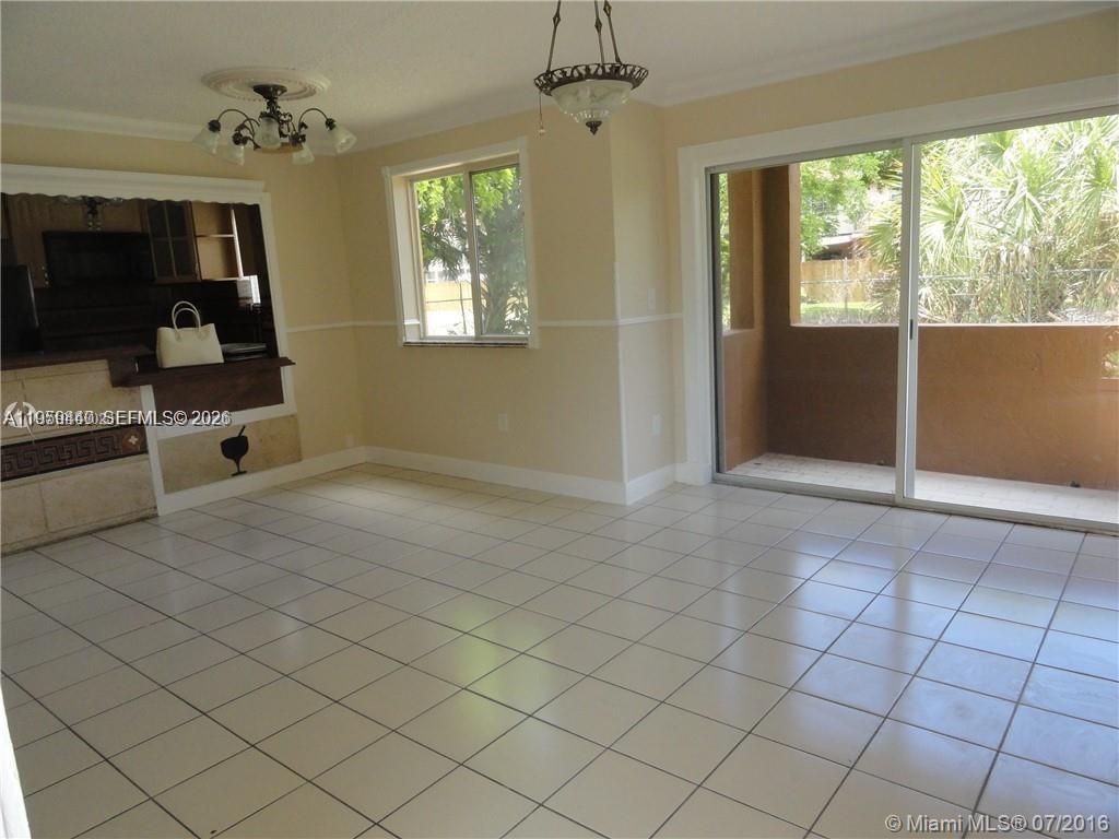 6205 Southwest 131st Court, Unit 104 Miami, FL 33183 - Photo 4 of 21 an empty room with chandelier fan and windows