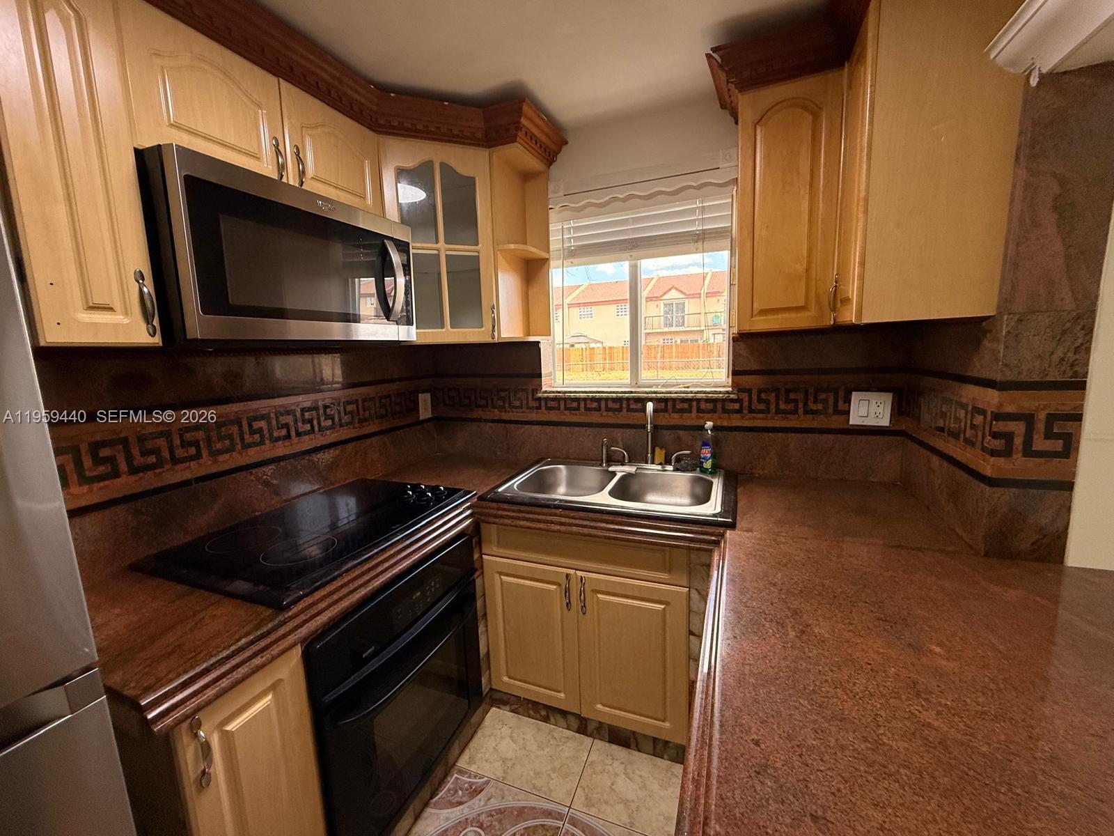 6205 Southwest 131st Court, Unit 104 Miami, FL 33183 - Photo 9 of 21 a kitchen with a stove and a microwave