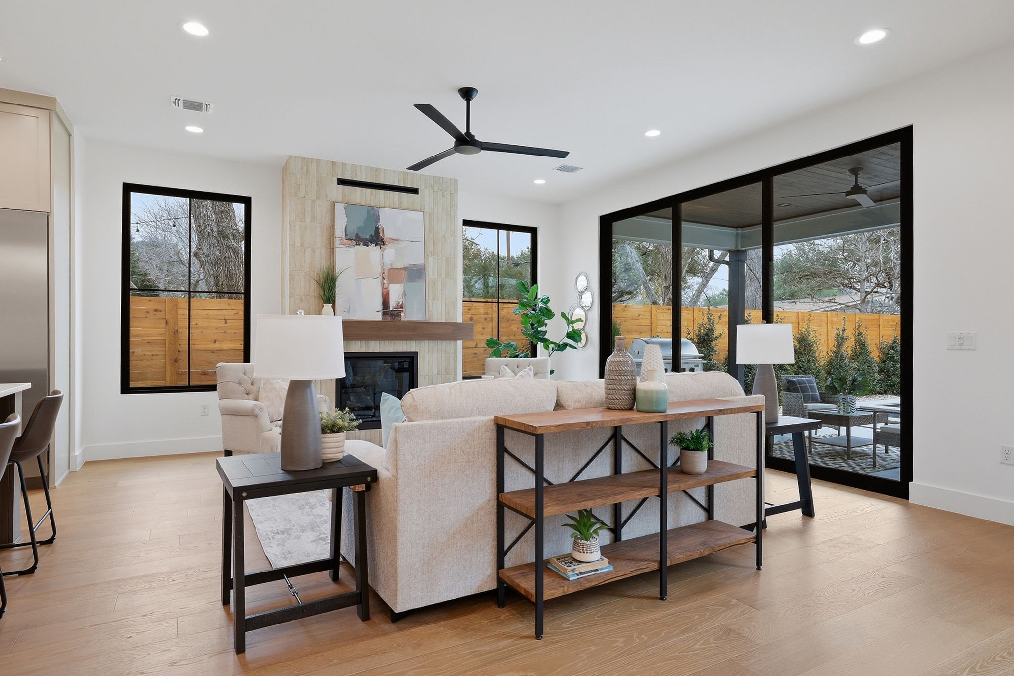 6611 Lexington Road Austin, TX 78757 - Photo 14 of 37 Spacious living area featuring wood-finish flooring, a fireplace with a light-toned stone surround and wood mantel, recessed lighting, and a ceiling fan