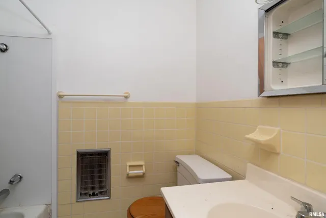 a bathroom with a sink a toilet and mirror