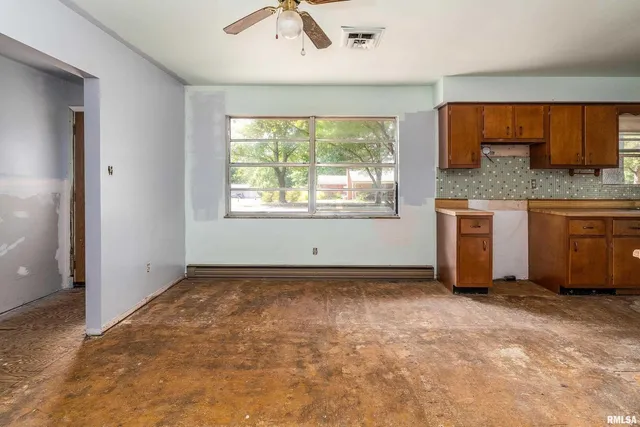 an empty room with a window and mirror