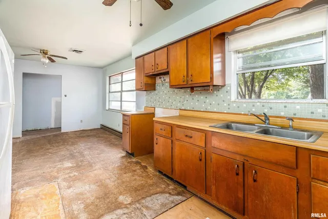 a kitchen with stainless steel appliances granite countertop a sink window and cabinets