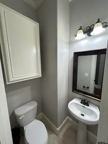 a bathroom with a toilet sink and mirror