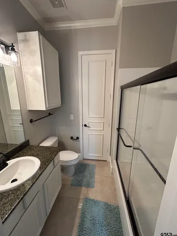 a bathroom with a granite countertop sink toilet and shower a mirror