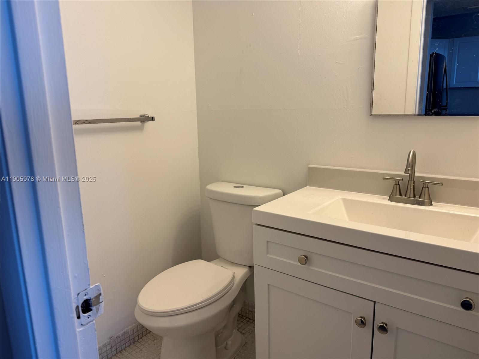 2025 Northeast 164th Street, Unit 714 North Miami Beach, FL 33162 - Photo 6 of 7 a bathroom with a sink a toilet and a mirror