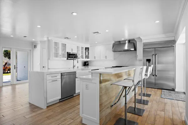 a kitchen with stainless steel appliances kitchen island granite countertop a refrigerator and microwave