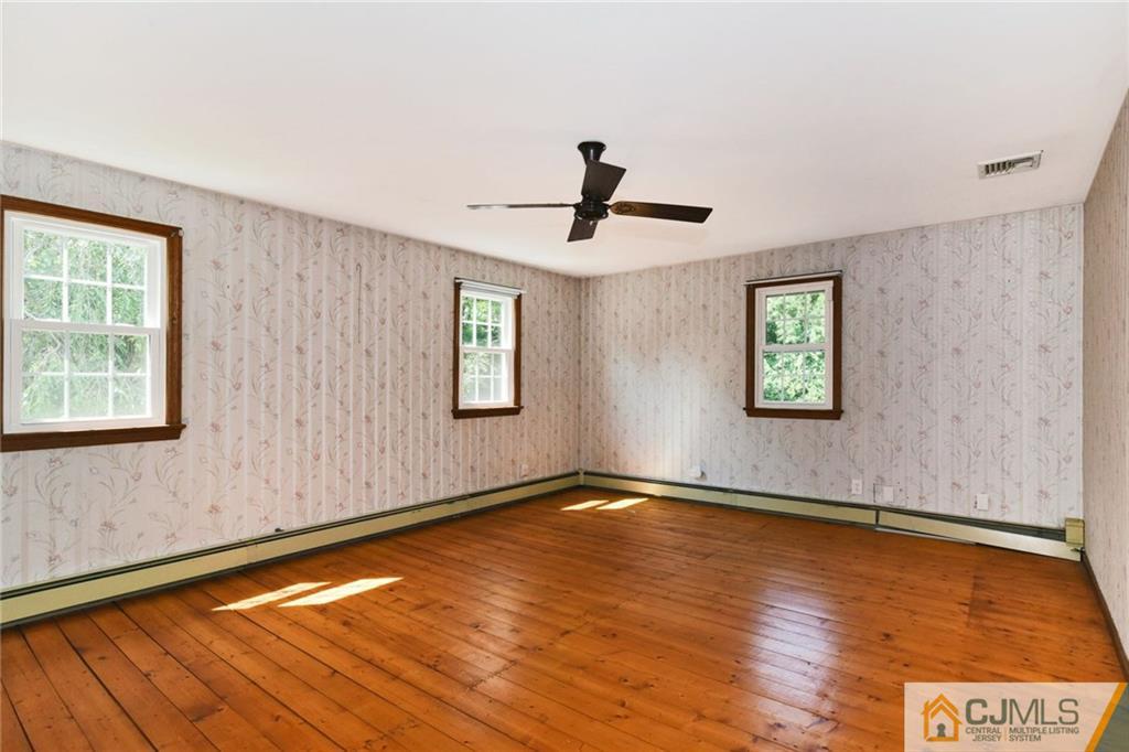 59 Spring Hill Road Old Bridge, NJ 07747 - Photo 16 of 24 a view of an empty room with wooden floor and a window