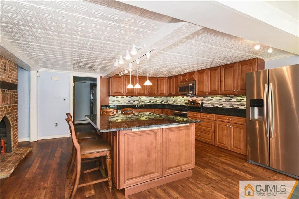 59 Spring Hill Road Old Bridge, NJ 07747 - Photo 5 of 24 a kitchen with stainless steel appliances granite countertop wooden cabinets a stove top oven a sink and dishwasher