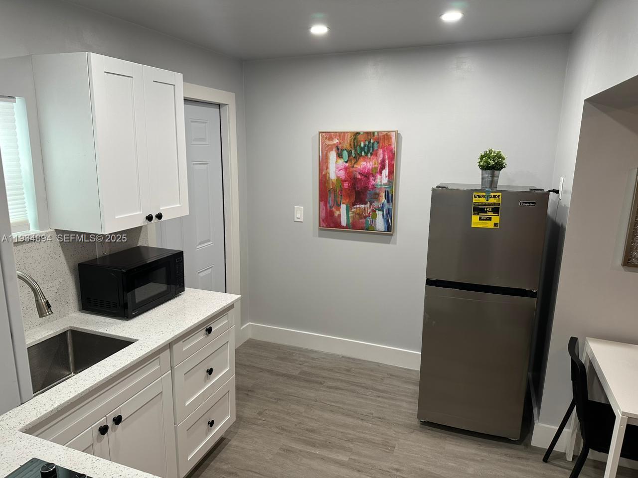 1822 Northwest 4th Street, Unit C Miami, FL 33125 - Photo 2 of 7 a kitchen with cabinets and stainless steel appliances