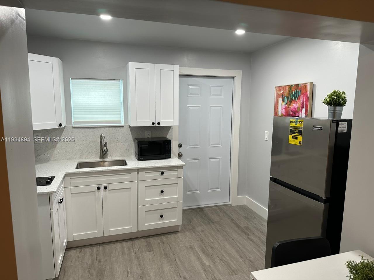 1822 Northwest 4th Street, Unit C Miami, FL 33125 - Photo 3 of 7 a kitchen with stainless steel appliances a refrigerator and a stove