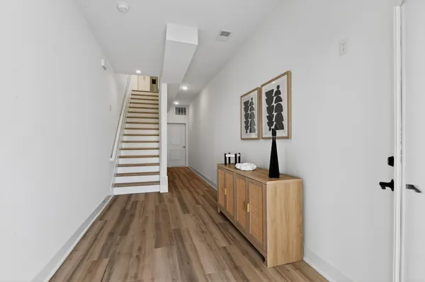a view of hallway with stairs and wooden floor