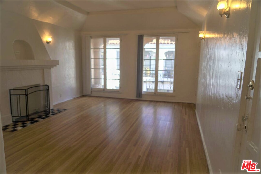 a view of a room with wooden floor and windows