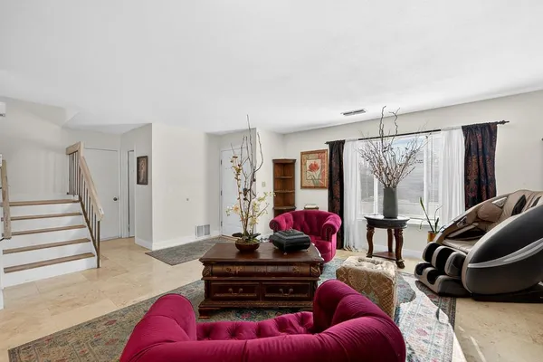 a living room with furniture a flat screen tv and a large window