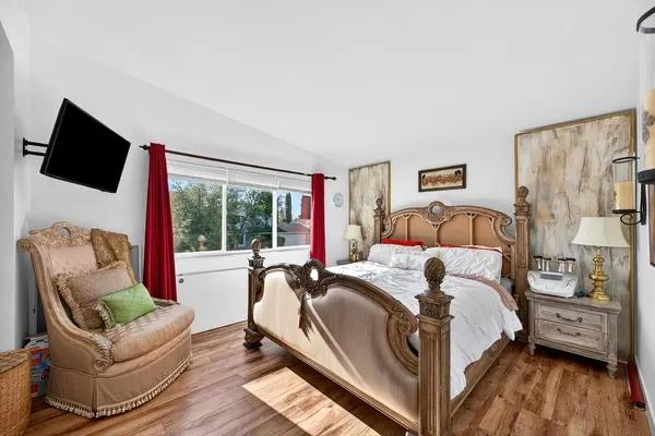 a bedroom with a bed and a large window with the outer view