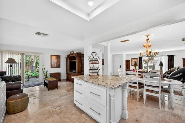 a view of living room kitchen with stainless steel appliances granite countertop furniture and a large window